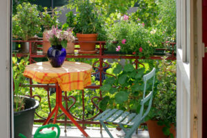 Balkon mit Tisch, Stuhl und vielen Pflanzen